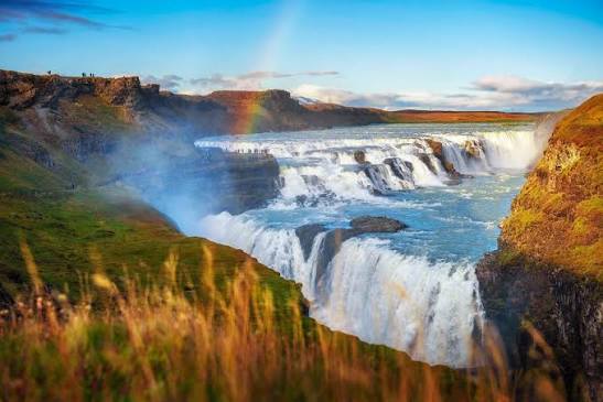 Rainbow over the wide terraced falls of Gullfoss in Iceland