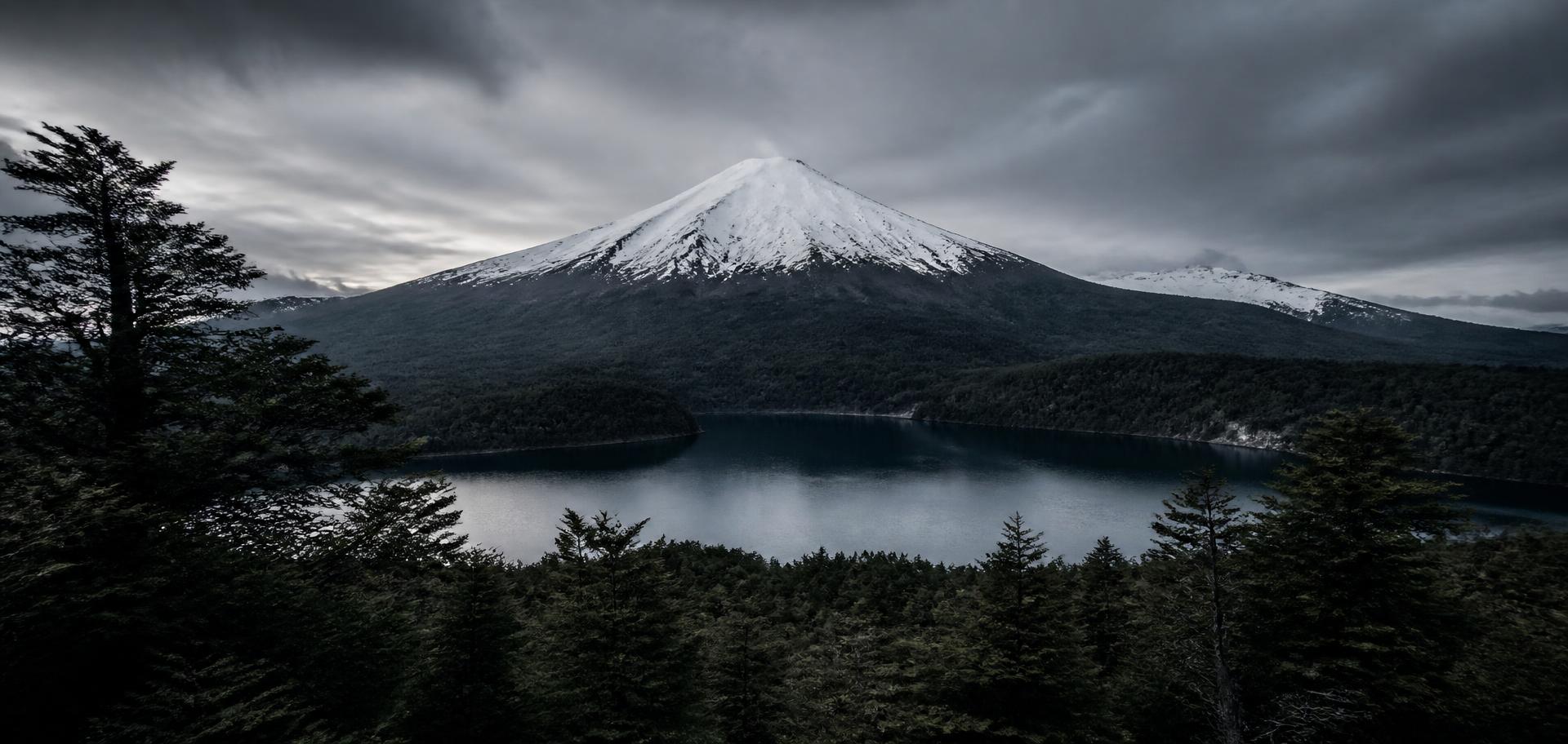 Snow-capped volcano above a still lake in Chilean Patagonia