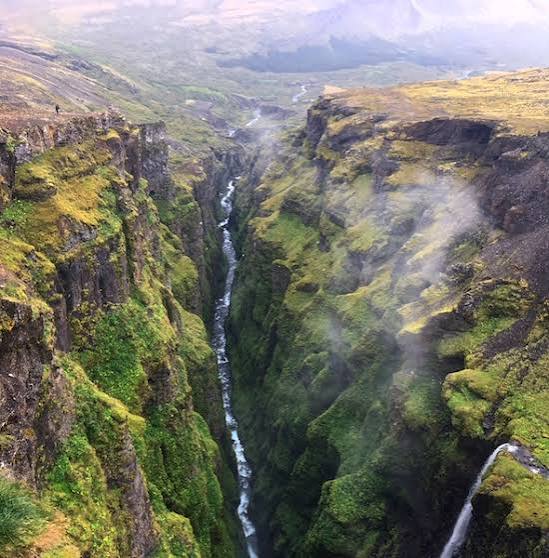 River running through a deep moss-covered Icelandic canyon
