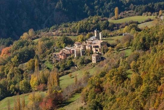 The stone village of San Martín de Veri on a wooded hillside in autumn